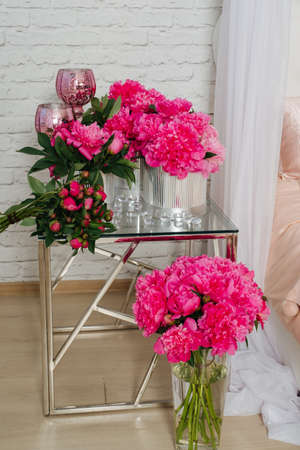 composition of peonies in silver boxes standing on a glass tableの写真素材