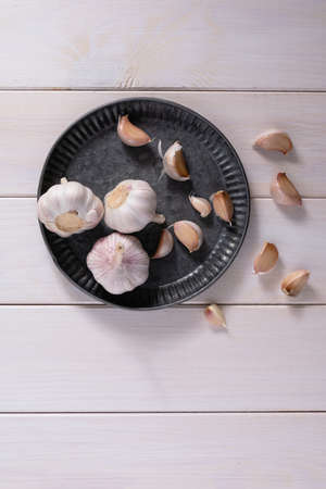 Onions and chives lie on a gray metal plate on a light wooden table. Spice. Rustic. Natural organic...