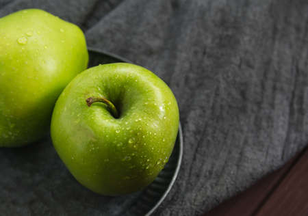 Two green apples on a gray background. Greeting card, place for your text. A symbol of a healthy lifestyle and proper nutrition. Fresh ecologically grown fruits.の写真素材