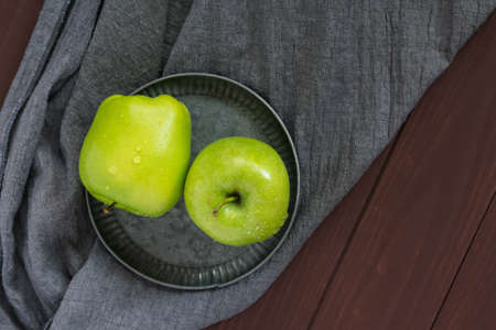 Two green apples on a gray background. Greeting card, place for your text. A symbol of a healthy lifestyleの写真素材