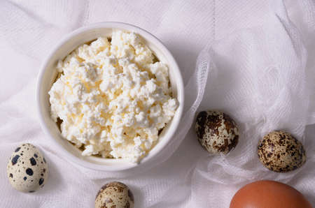 Cottage cheese and quail eggs on a light background top view.の写真素材