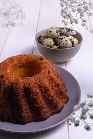 Easter cake with quail eggs raisins and white gypsophila. Festive card in light colors.