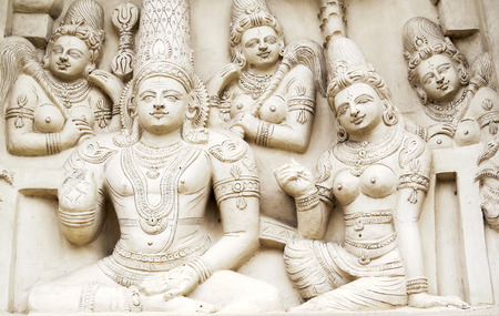 Sculptural images of Shiva and Parvati in accompaniment of the retinue on the wall of an ancient...