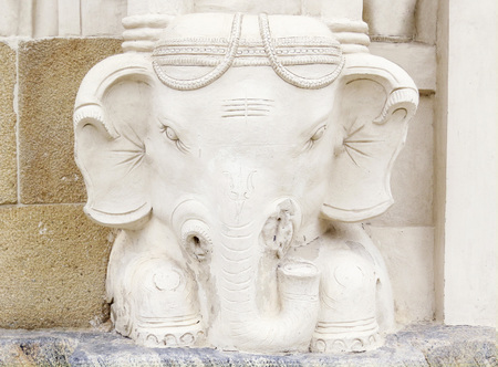 A sculpture of an elephant's head at the foot of one of the ancient temples. South India.の写真素材