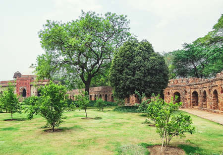 A view of the park, the ancient fortress wall and the old mosque of Isa Khan's 16th century away near architectural complex Humayun Tomb in New Delhi, Indiaのeditorial素材