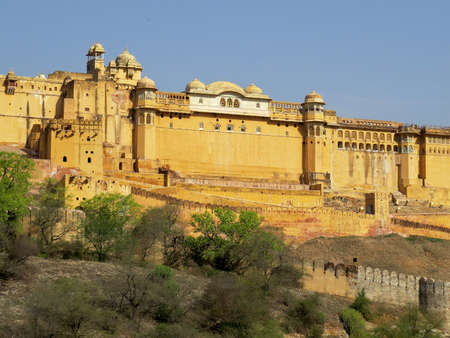View of part of the fortress walls and towers of the ancient fort Amber on the hill lit midday sun. Jaipur, India.のeditorial素材