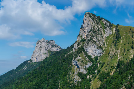 A rugged mountain peak in the French Alps, with green slopes and clear summer sky, captured near Talamarcheの写真素材