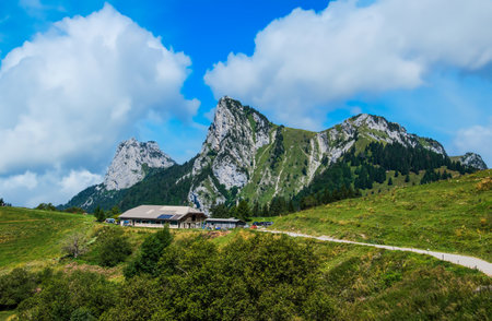 Mountain hut beneath rocky peaksの写真素材