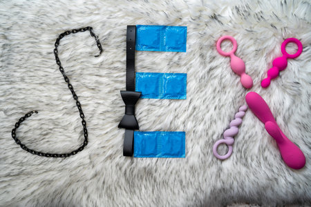 the word sex made of sex toys and condoms on gray fur background, concept of seduction, introduction to couple gameの写真素材
