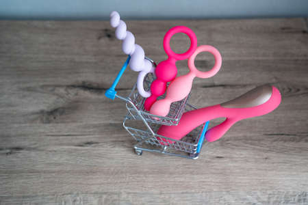 supermarket trolley filled with sex toys vibrator and anal butt plugs. Concept of buying adult toys, e shoppingの写真素材