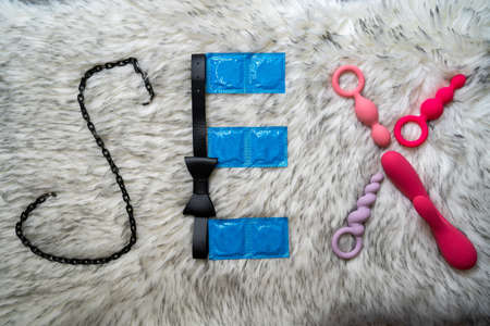 the word sex made of sex toys and condoms on gray fur background, concept of seduction, introduction to couple gameの写真素材