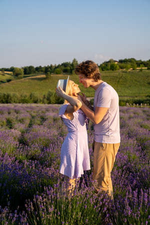 couple in purple matching lilac outfit, hugging, kissing in lavender field. Romantic date concept, perfect relationship. Good picture for cover, calendar, postcard, wallpaperの写真素材
