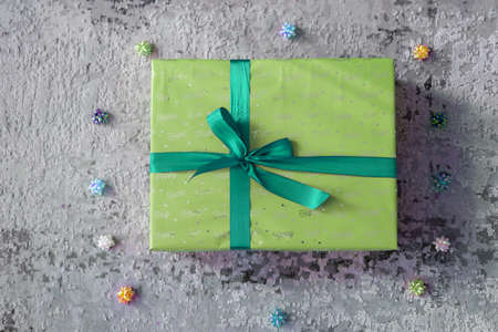 top view of green turquoise color gift box with green ribbon bow on grey wooden background. Concept: holiday, celebration, birthday, New Year, Christmas, Valentines Day, Mothersの写真素材