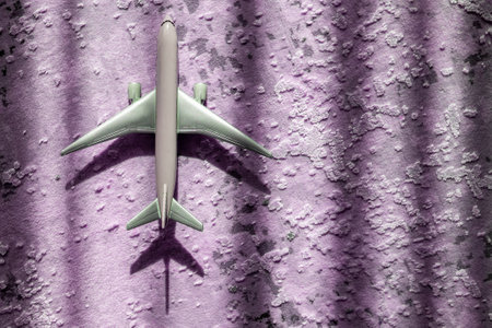 creative effect with sun light beam, airplane aircraft toy on purple violet background with lines, travelling conceptの写真素材