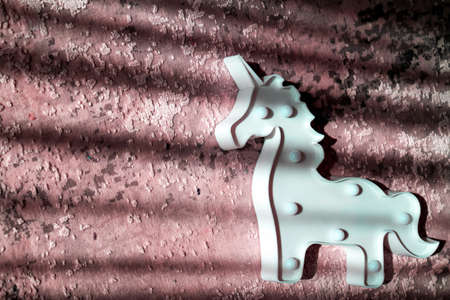 creative light effect, sunbeam stripes on light red background, white unicorn toy lamp, children toysの写真素材