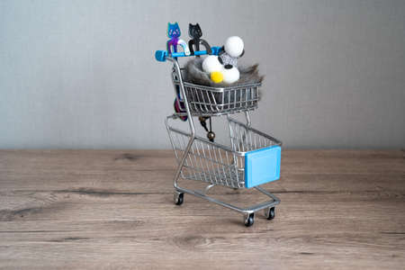 two spoons in the shape of cat on the shopping cart, plush toy penguin in the trolley, kids shopping, funの写真素材