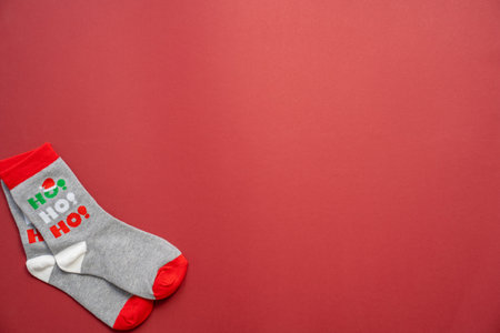 christmas and new year's socks on a red background, festive season, holiday clothes ho ho ho, copy spaceの写真素材