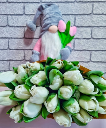 beautiful bouquet of spring flowers, toy nisse gnome with tulips, dwarf in grey hat, happy international woman's day 8 march, congratulations to mother's dayの写真素材