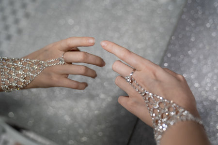 elegant woman hand with silver jewelry bracelet and ring. Reflection of hand in the mirror. Creative effect. Touching own reflection. Concept of loving and accepting yourself.の写真素材
