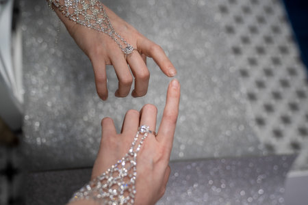 elegant woman hand with silver jewelry bracelet and ring. Reflection of hand in the mirror. Creative effect. Touching own reflection. Concept of loving and accepting yourself.の写真素材