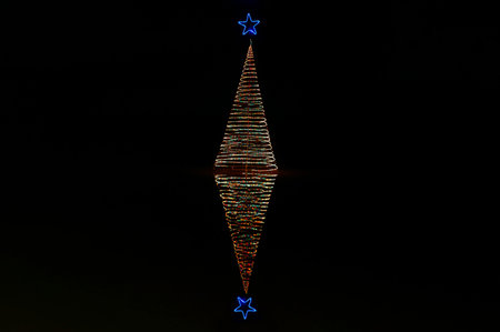 decorated christmas tree with lights  on black background. Christmas and New Year. Garland illumination on new year tree. Reflection on water. Infinity treeの写真素材