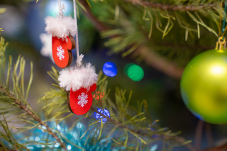 christmas decorations with fir tree branches, red santa gloves toys hanging on christmas tree. Happy holidays. Decoration of New Year treeの写真素材