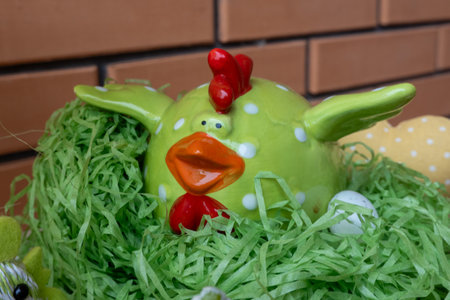 easter chicken ceramic figure on green grass in nest with eggs. Happy Easter holidayの写真素材
