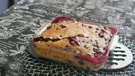 Homemade cherry pie baked in a rectangular glass baking dish with a golden crust and visible juicy...