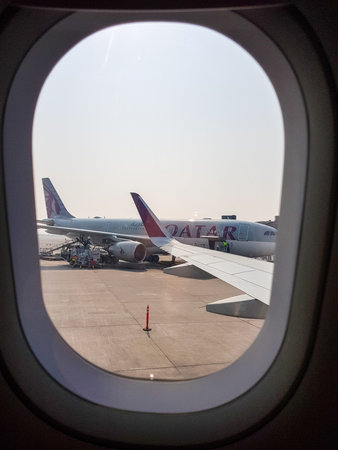 Doha, Qatar â€“ February 5, 2025: View through an airplane window showing Qatar Airways...