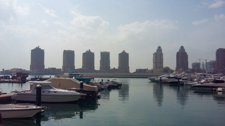 Doha, Qatar - March 19 2026: Luxury yachts moored at marina with modern skyline in The Pearl-Qatar...