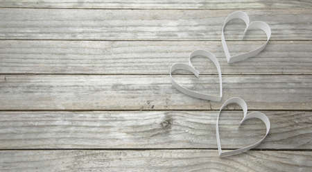 Three white hearts on a wood backgroundの写真素材