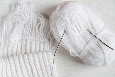 Ball of white yarn on a white wooden background. Knitting pattern.の写真素材