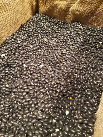 Raw black beans in a sack cloth close upの写真素材