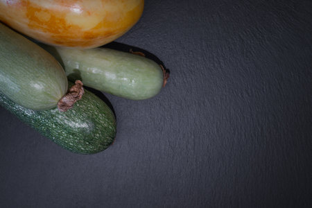 Zucchini on black slate background. Top view with copy space