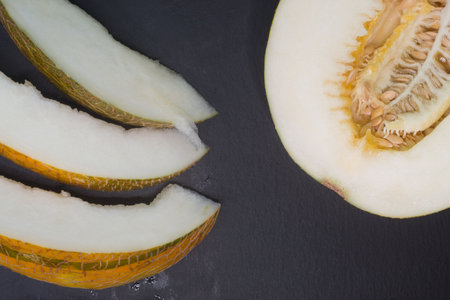 Melon cut in half on a black background. Selective focus.の写真素材