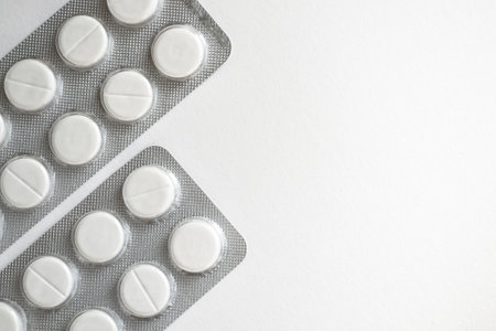 Tablets in blister pack on white background with copy space for text.