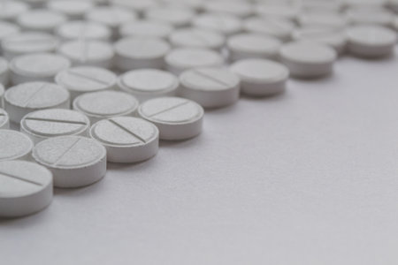 White pills on a white background. Focus on foreground, soft bokeh.の写真素材