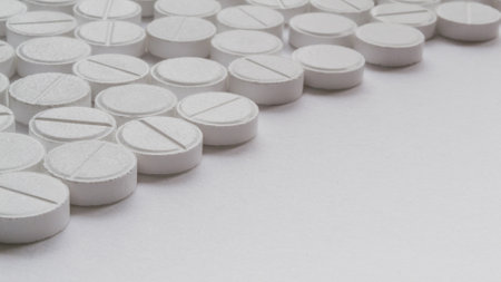 White pills on a white background. Focus on foreground, soft bokeh.の写真素材