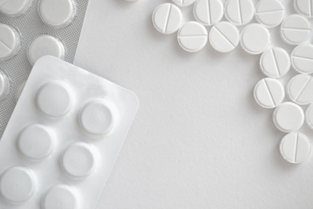 White pills on a white background with copy space. Top view.
