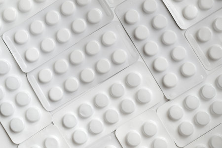 Tablets of various shapes and sizes in blister packs. White background.の写真素材