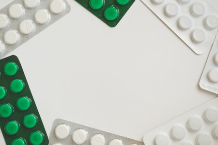 Tablets and pills packed in blisters on white background with copy spaceの写真素材