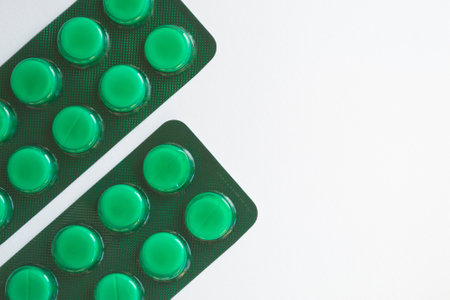 Green pills in blister pack on white background. Top view. Copy space.の写真素材