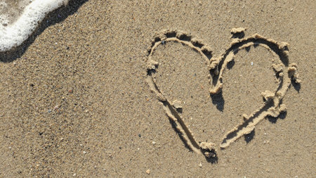 Heart drawn in the sand on the beach. The concept of love and romance.の写真素材