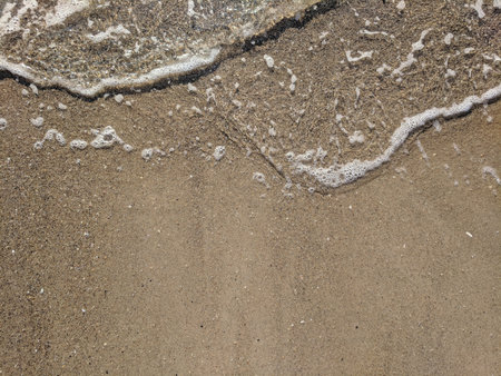 Soft wave of the sea on the sandy beach close-up.の写真素材