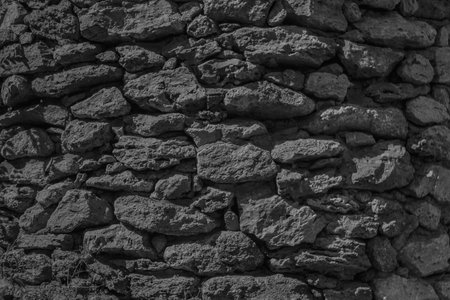 Black and white photo of an ancient stone wall. Background and texture.の写真素材
