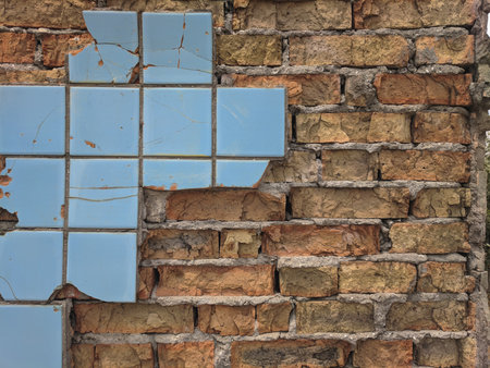 Old brick wall with broken blue ceramic tiles. Abstract background and texture.の写真素材