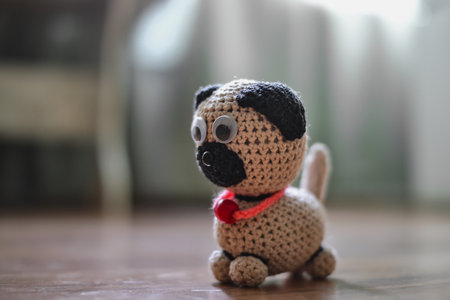 Cute handmade knitted toy sitting on the floor at home