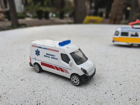 Ambulance car toy on the ground in front of a police carの写真素材