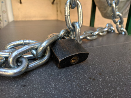 Padlock and chain on a table in a cafe, closeup of photo