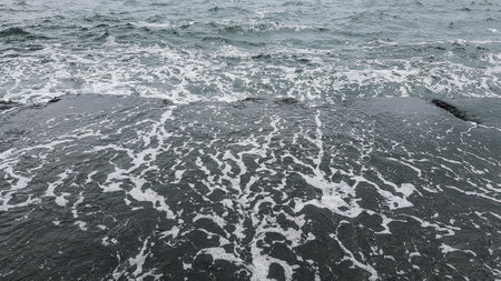 Sea waves breaking on the shore of the island of Santoriniの写真素材